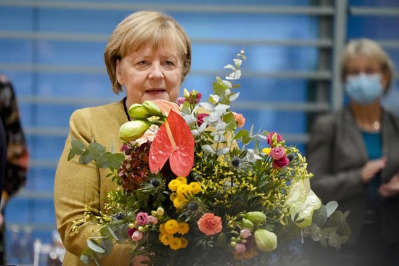 German Chancellor Angela Merkel holds a bouquet from Vice Chancellor and Finance Minister Olaf, Scholz prior to the cabinet meeting at the chancellery in Berlin, Germany. (Photo / AP)