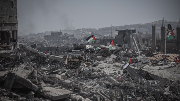 Palestinian flags are seen among the rubble of destroyed buildings as residents continue to return to northern Gaza following the ceasefire and the withdrawal of Israeli forces on October 13, 2025. (Photo by Ahmed Jihad Ibrahim Al-arini/Anadolu via Getty Images)