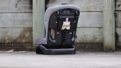 A child's car seat sits the Manurewa driveway where 10-month-old Poseidyn Pickering was injured in 2020. Photo / NZME