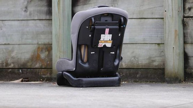A child's car seat sits the Manurewa driveway where 10-month-old Poseidyn Pickering was injured in 2020. Photo / NZME