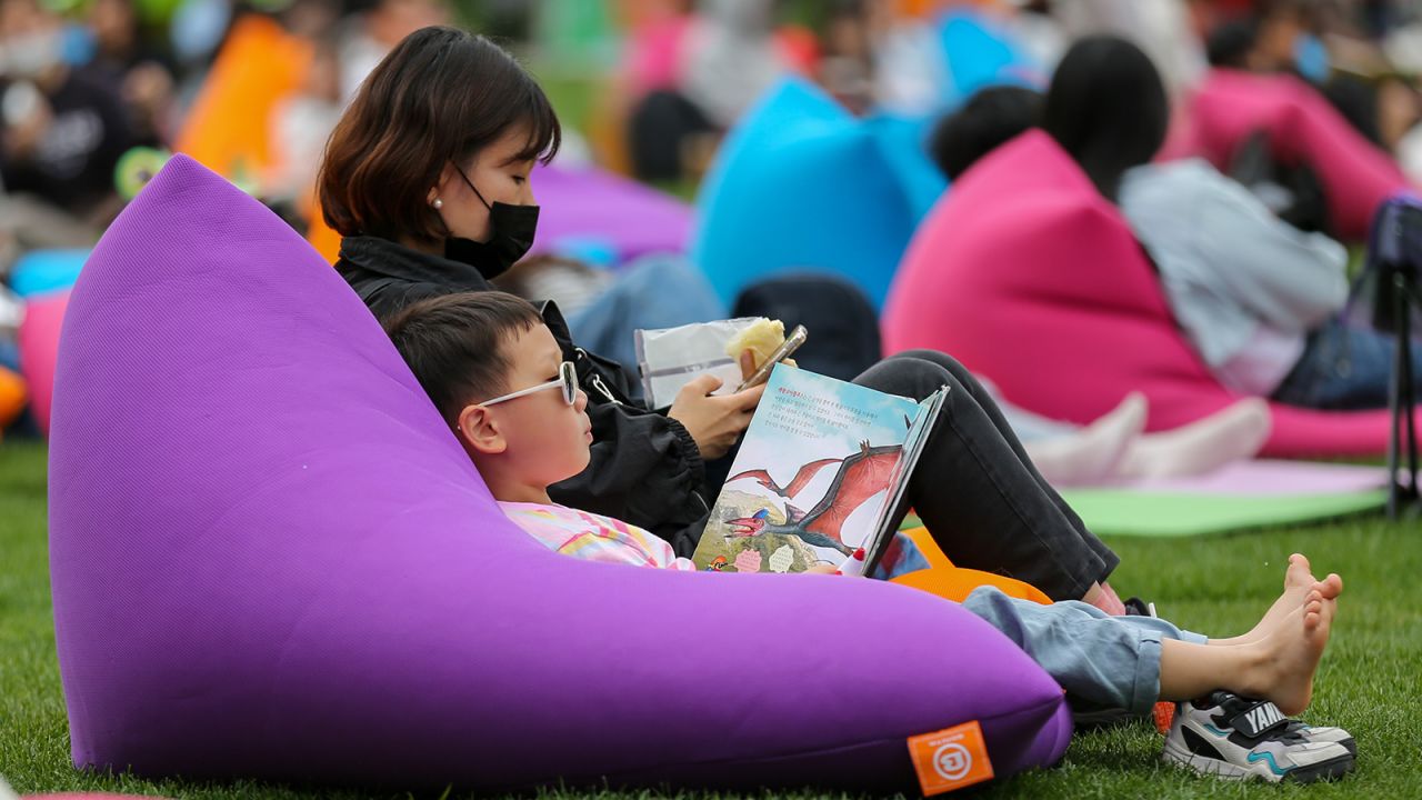 A child reads a book at Seoul Plaza in Seoul, South Korea, on April 23, 2023. Wang Yiliang/Xinhua/Getty Images