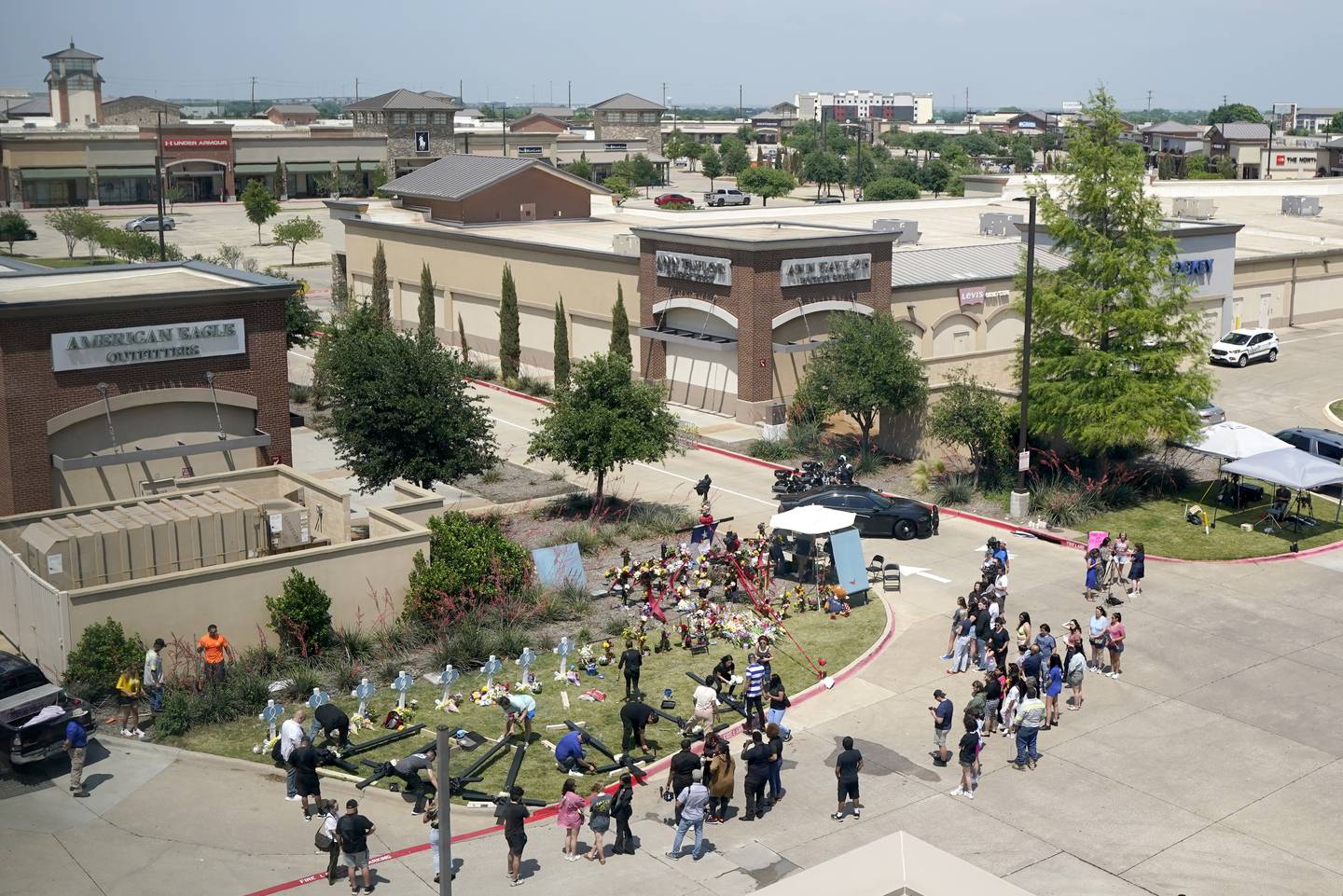 People gather around a makeshift memorial outside of a mall where several people were killed in a mass shooting, in Allen, Texas. Photo / AP