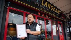 Henry Hew, owner of Langkawi Restaurant in Milford, holding a certificate showing he had pest control work carried out. Photo / Sylvie Whinray