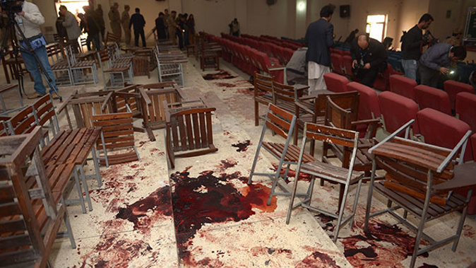 A Pakistani video cameraman shoots video of the bloodied floor in the ceremony hall at an army-run school a day after an attack by Taliban militants in Peshawar on December 17, 2014 (Getty Images)