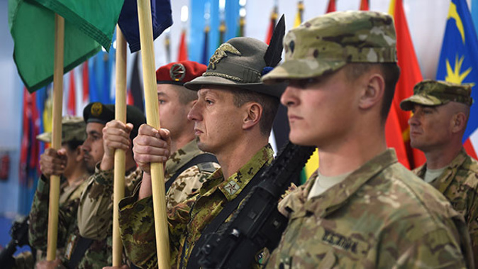 NATO-led International Security Assistance Force (ISAF) soldiers carry flags during a ceremony marking the end of ISAF's combat mission in Afghanistan at ISAF headquarters in Kabul on December 28, 2014. (Getty)