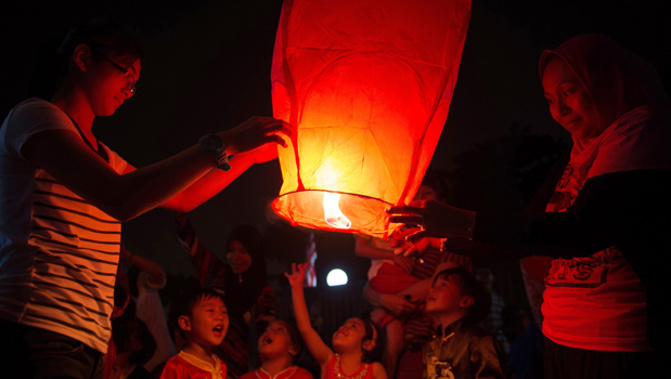 Some youths light up a sky lantern (Getty Images)