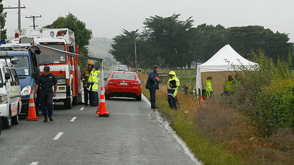 Policemen and firefighter personnel are seen at the site where 11 people were killed when their hot air balloon hit power lines in Carterton, near Wellington on January 8, 2012. (Getty)