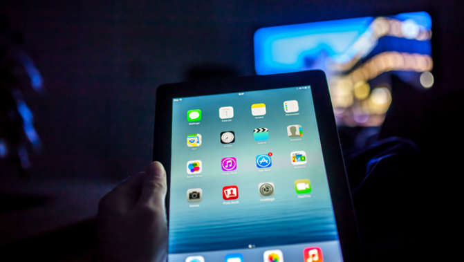 A person using an iPad and watching TV (Getty Images)