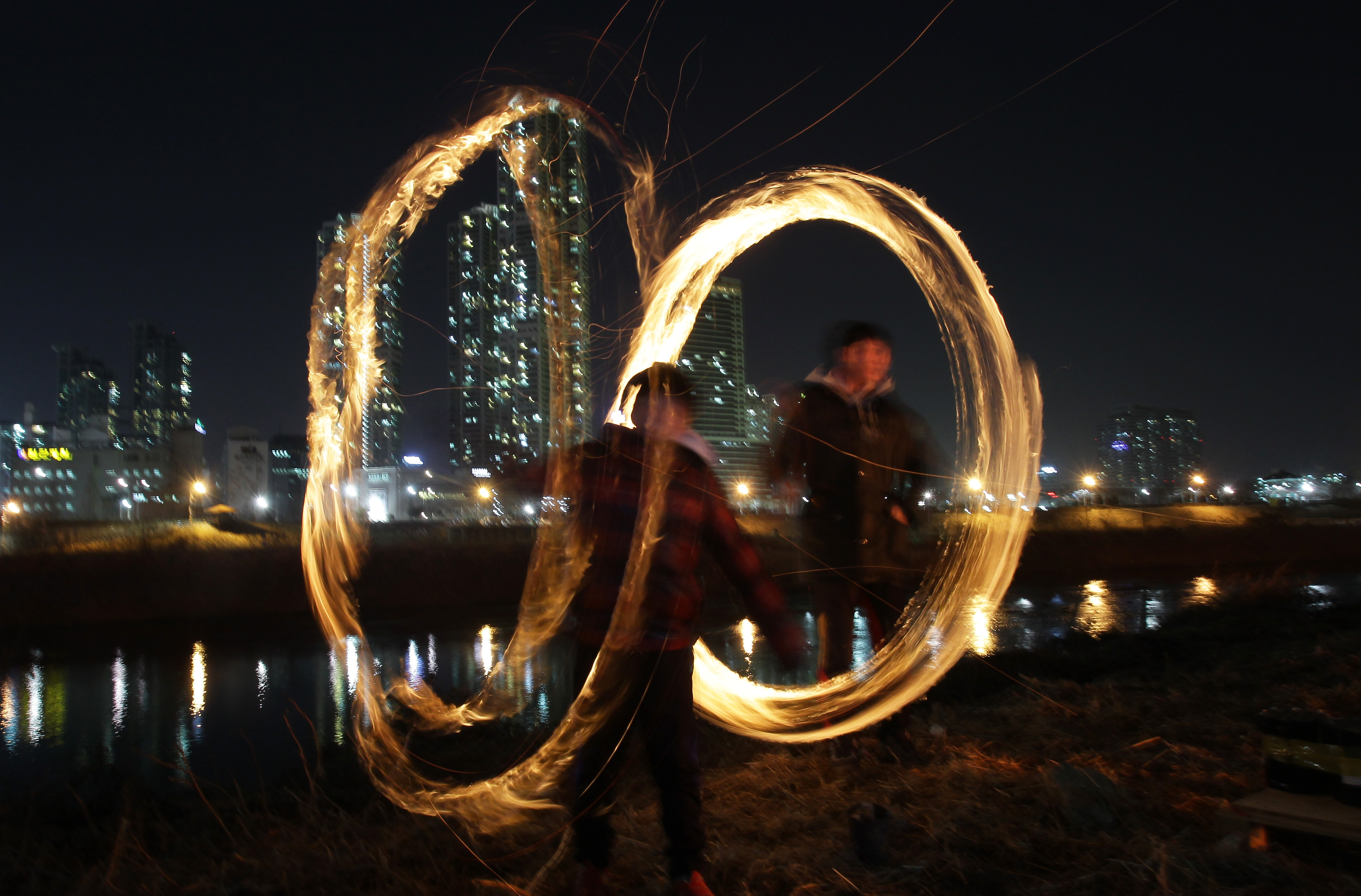 South Koreans spin fire cans during 'Jwibulnoli' a South Korean folk game.