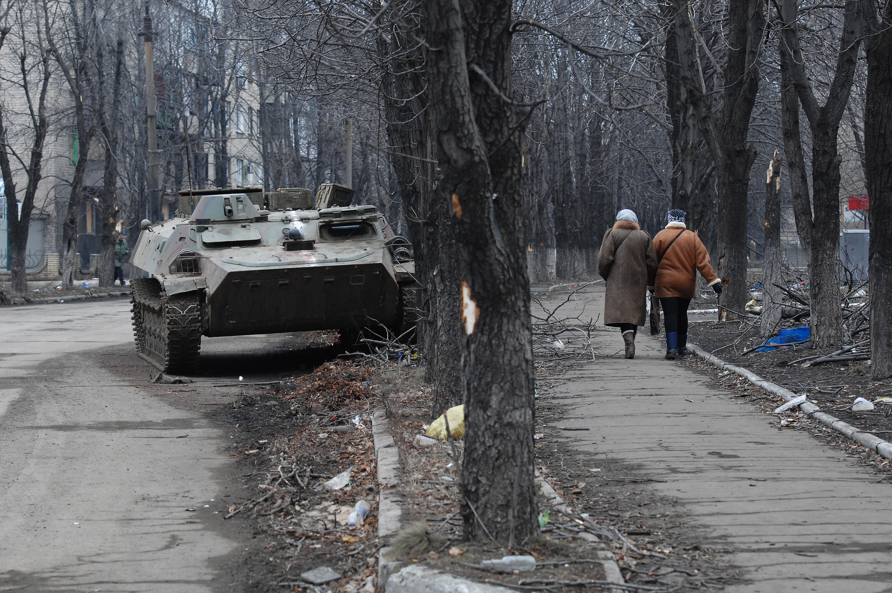 Two Ukrainian women walk past a wrecked armored personnel carrier as Debaltseve copes with the aftermath of a siege and then capture by Russian-backed separatists from the Ukrainian Army of Debaltseve, Ukraine, on March 3, 2015.