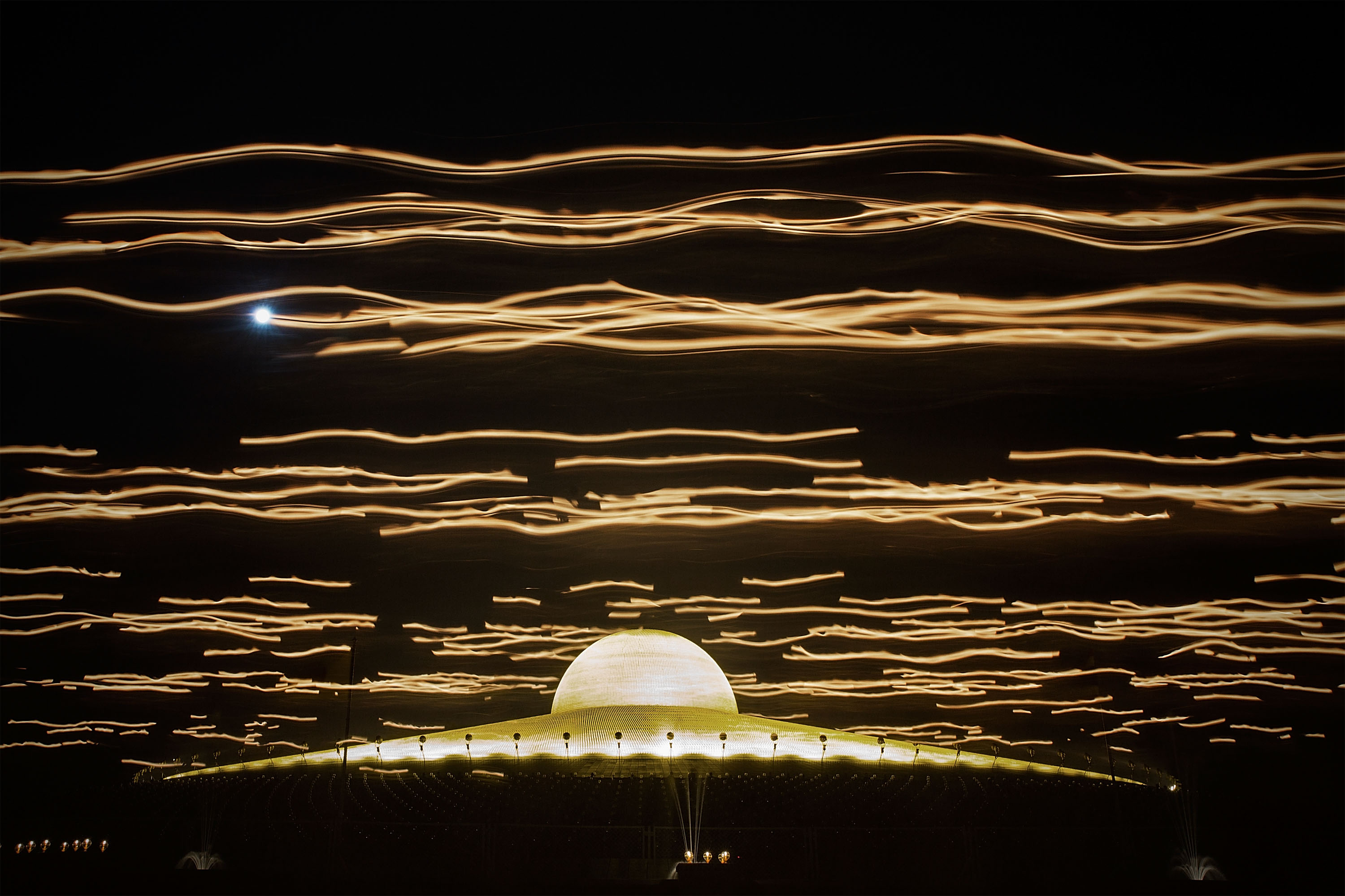 A long exposure of a procession of laypeople carrying candles during a ceremony on March 4, 2015 at Wat Phra Dhammakaya in Bangkok, Thailand.