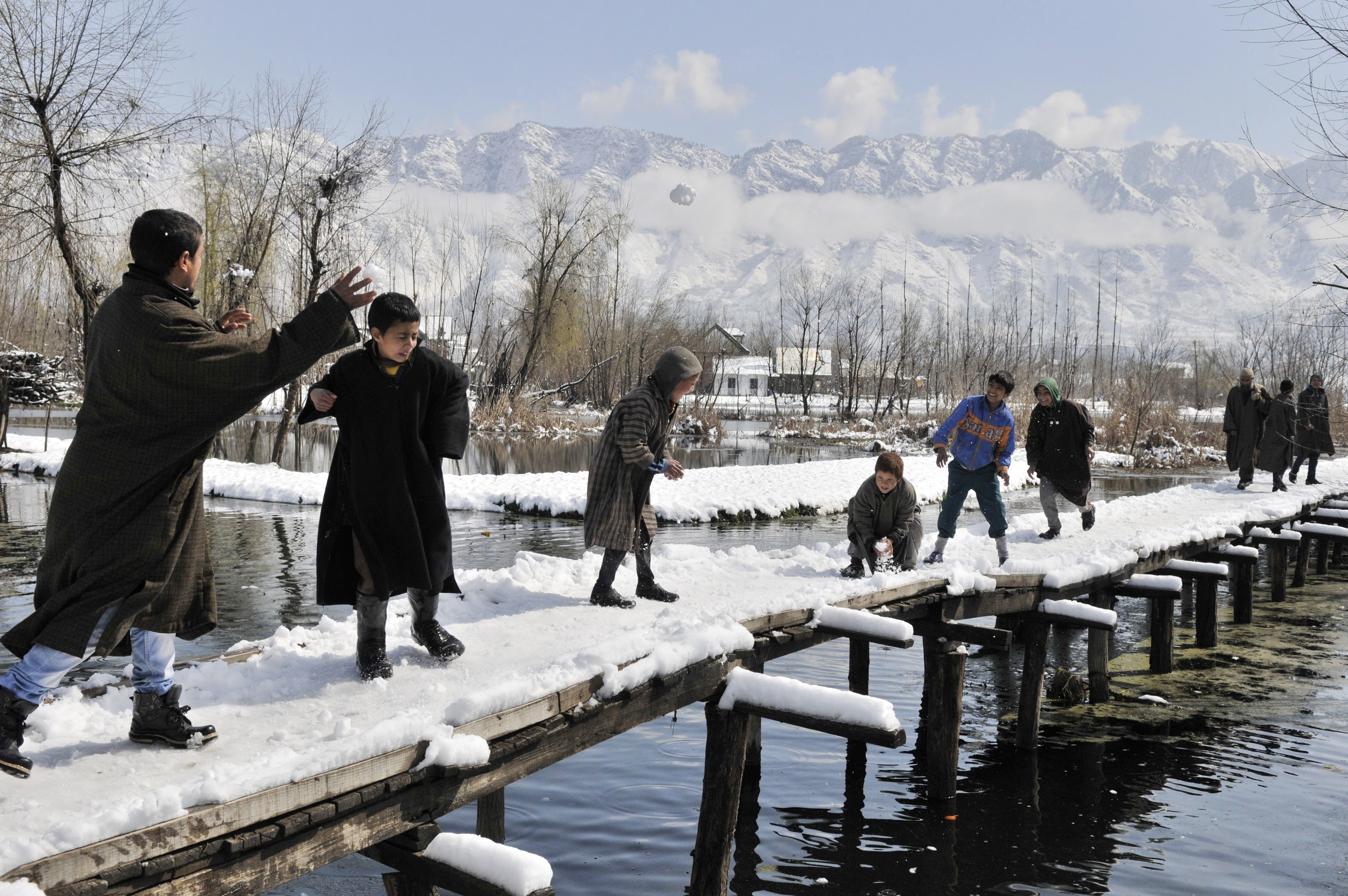Kashmiri boys enjoys snow ball fight after a fresh snowfall on the outskirts of Srinagar, India.