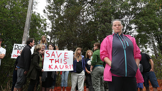 Local resident Aprilanne Bonar (R) leads the protesters as Michael Tavares sits high in a Kauri tree on a property in Paturoa Rd, Titirangi (Getty Images)