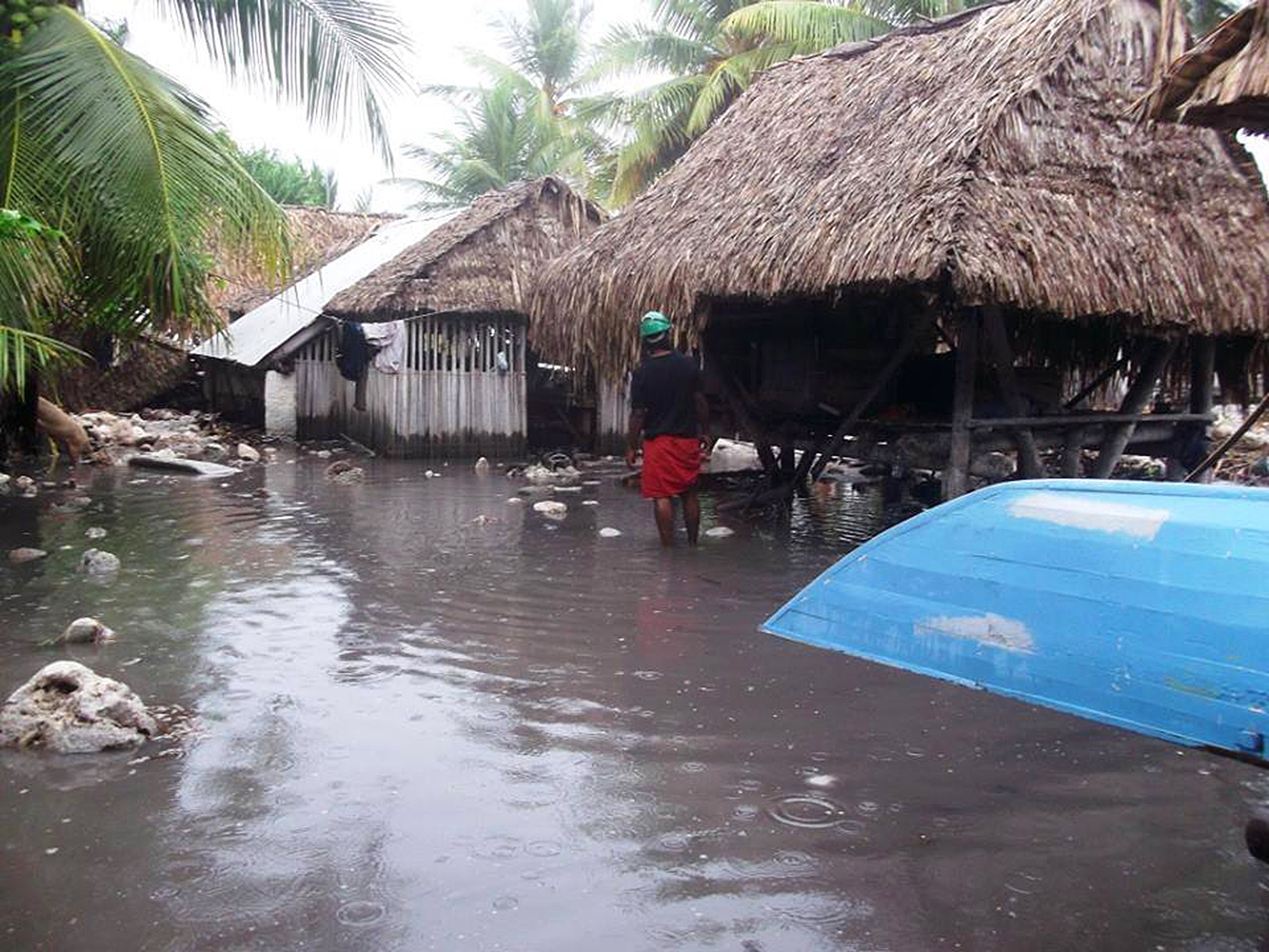 A man stands in floodwaters in Kiribati.