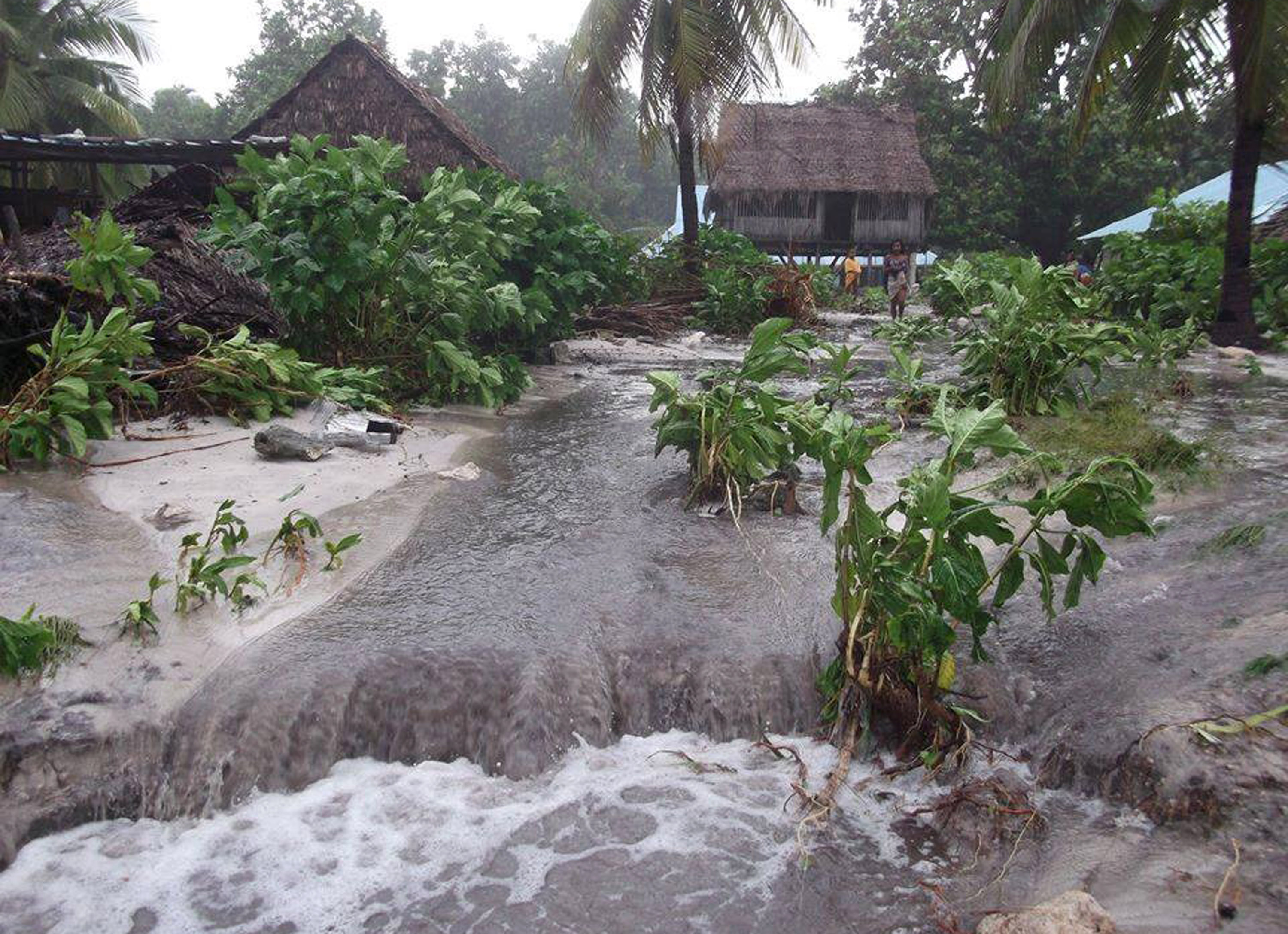 Floodwaters rush through a village on the island of Kiribati.