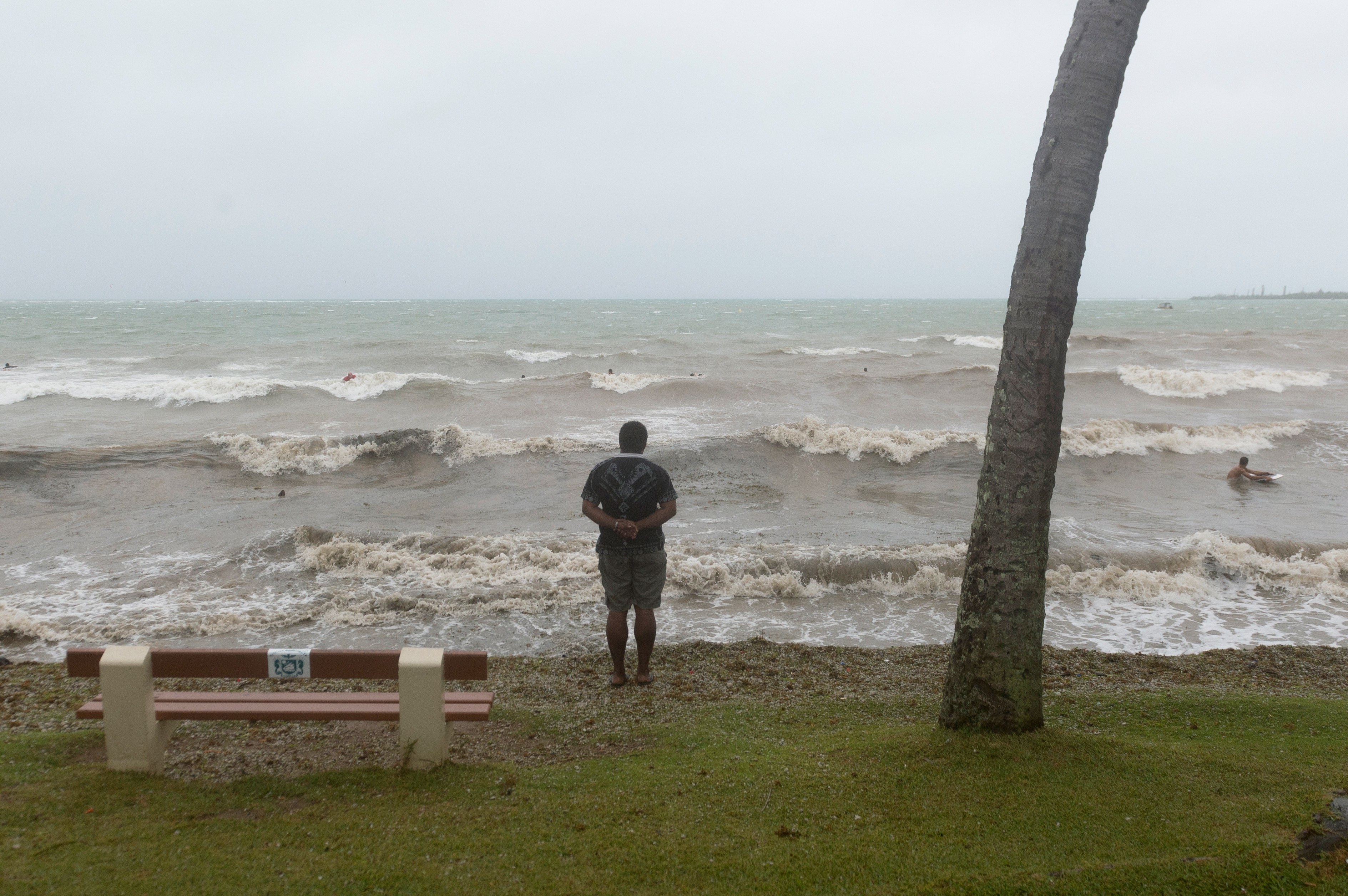 A man watches on as waves crash in New Caledonia.