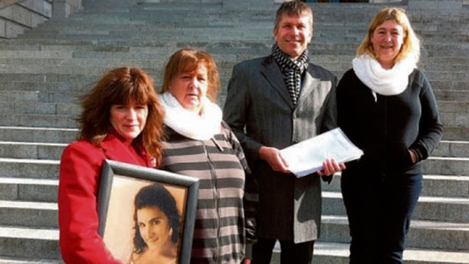 Karen Edwards (left) holds a photo of her daughter Ashlee as the petition for tougher laws on protection order breaches was presented at Parliament