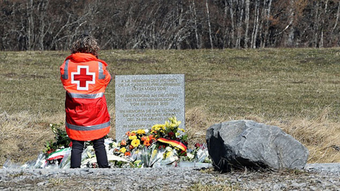 A Red Cross member pays tribute for the victims of the Germanwings plane crash in front of a memorial in Le Vernet (Getty Images) 