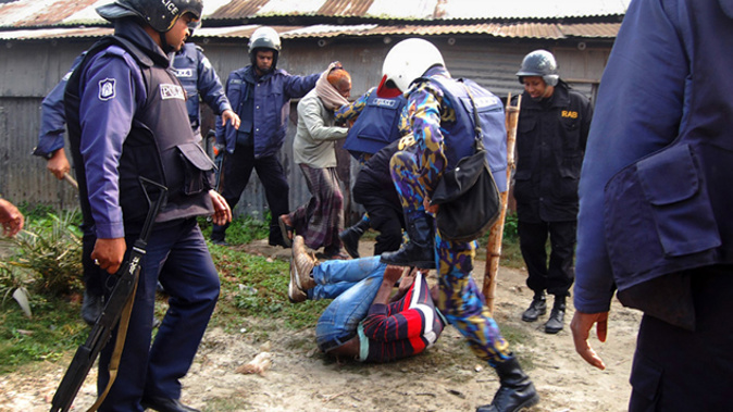Bangladeshi police beat a suspect following an attack on a polling station in the northern town of Bogra on January 5, 2014. Protestors firebombed polling stations and attacked police as Bangladesh went ahead with a violence-plagued election boycotted by the opposition. (Getty Images)