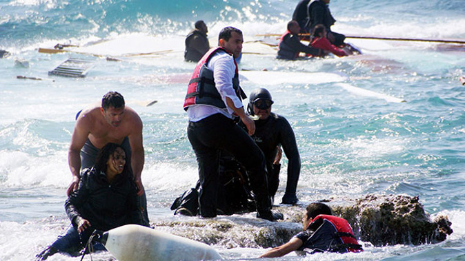 Local residents and rescue workers help a migrant woman after a boat carrying migrants sank off the island of Rhodes, southeastern Greece, on April 20, 2015 (Getty Images) 