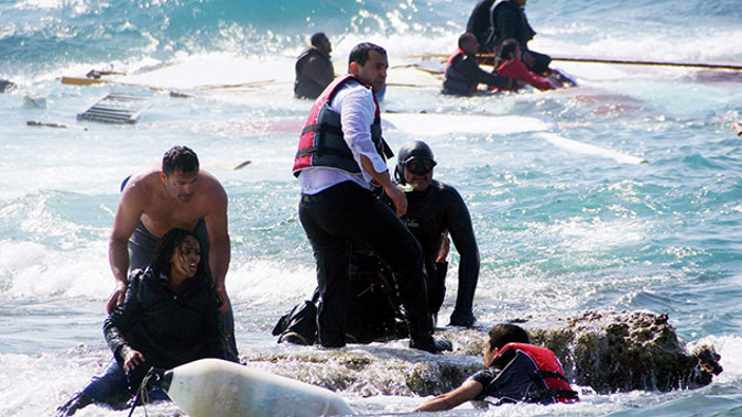 Local residents and rescue workers help a migrant woman after a boat carrying migrants sank off the island of Rhodes, southeastern Greece, on April 20, 2015 (Getty Images)