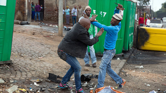 Mozambican national, Emmanuel Sithole, is brutally attacked by men in the Alexandra township during a xenophobic attack on April 18 (Getty Images) 