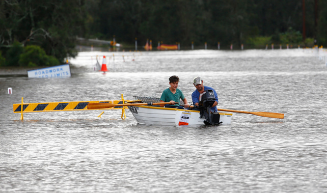 People use a boat on a flooded road on April 22, 2015 near Dungog, Australia (Getty Images) 