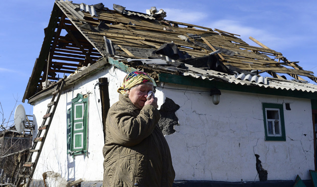 n elderly woman wipes her eye as she stands in front of a damaged house in Nikishyne, south east of Debaltseve March 11, 2015 (Getty Images) 
