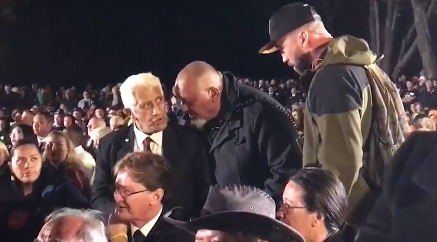 Paumea McKay is ushered away from the Waitangi dawn service after interrupting proceedings.