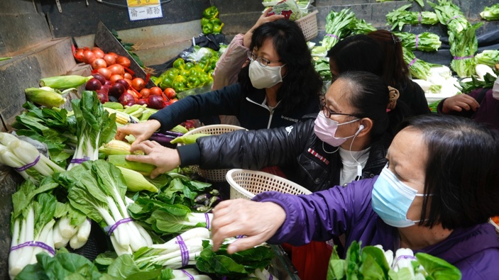 Customers wearing face masks buy fresh vegetable at a wet market store in Hong Kong, Wednesday, Feb. 9, 2022. (Photo / AP)