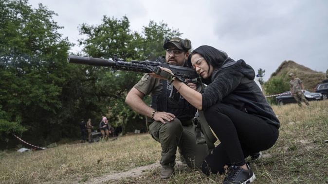 A woman fires an AK-47 during tactical training for civilians near Zaporizhzhia, Ukraine. Photo / AP