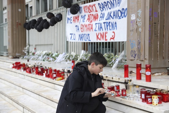 A boy lights a candle outside a court in Larissa city, about 355 kilometres (222 miles) north of Athens, Greece, Sunday, March 5, 2023. The station master involved in Greece's deadliest train crash is set to appear to a prosecutor and an examining magistrate on Sunday. Photo / AP
