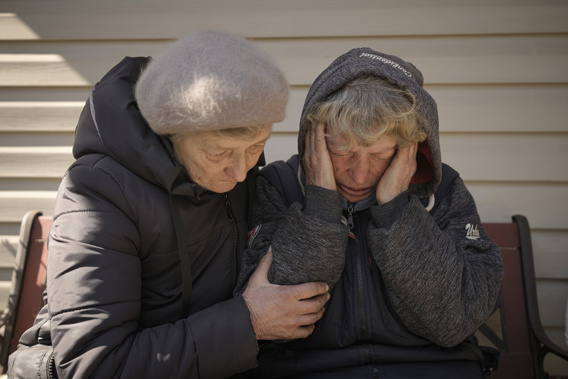 A neighbor comforts Natalia Vlasenko, whose husband, Pavlo Vlasenko, and grandson, Dmytro Chaplyhin, called Dima, were killed by Russian forces, as she cries in her garden in Bucha, Ukraine, Monday, April 4, 2022. Russian soldiers picked up Dima during a March 4 sweep, accused him of being a spotter helping the Ukrainian military. Asked “What would justice be for you?,” the grandmother of 20-year-old Dima says, “I- I- I can’t even- I don’t know. These scoundrels…" Photo / AP