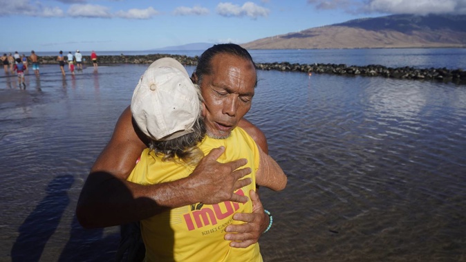 Vicente Ruboi receives a hug after performing a blessing to greet the day in Kihei, Hawaii, yesterday. Photo / AP
