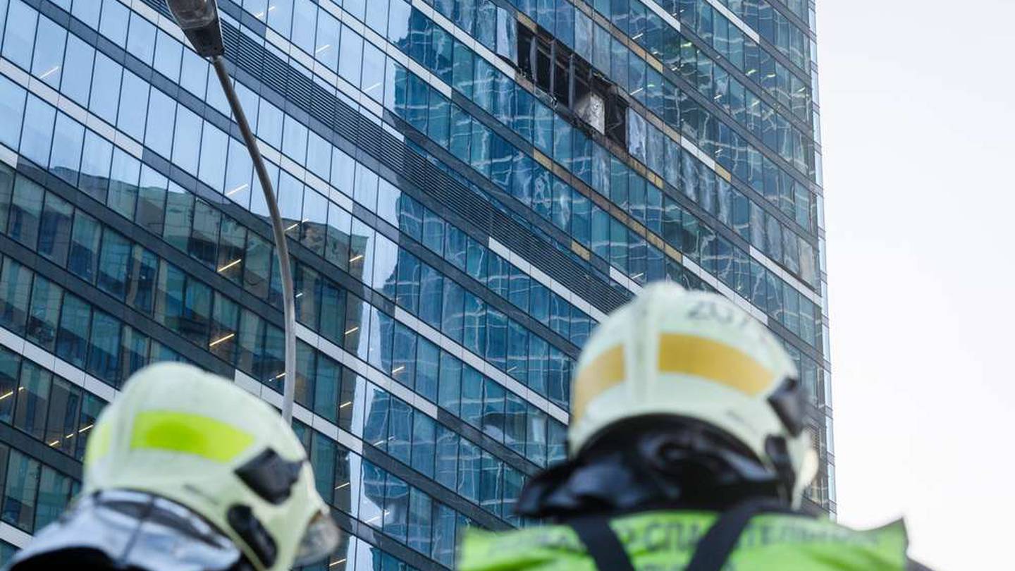 Firefighters stand next to a damaged building in the "Moscow City" business district after a reported drone attack. Photo / AP