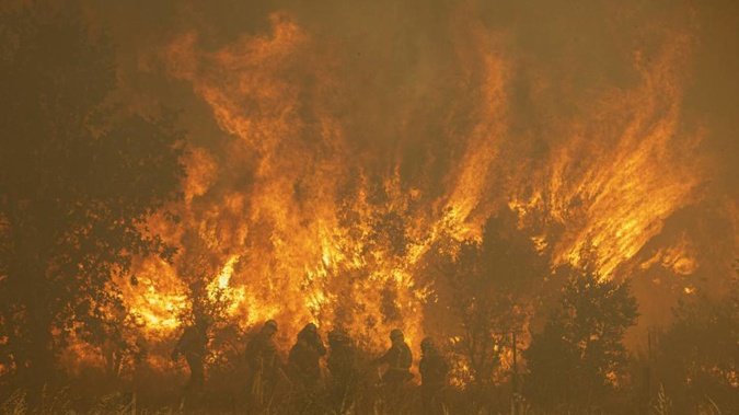 Firefighters work in front of flames during a wildfire in the Sierra de la Culebra in the Zamora Provence. Photo / AP