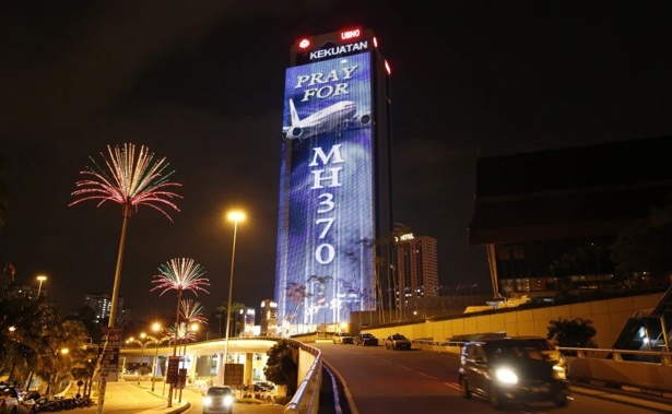 An office building is illuminated with lights displaying Pray for MH370 in Kuala Lumpur, Malaysia, March 24, 2014.