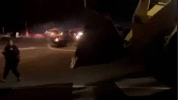 The loader is driven towards a group of boy racers on Mahuta Station Rd on Friday night. (Photo / rfbdaily)
