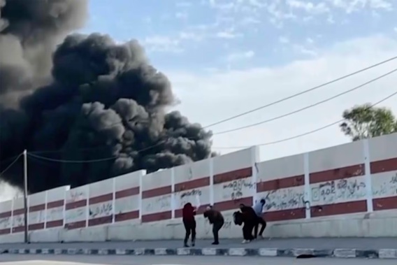 This image made from ITV News video shows a group of five men trying to take cover while walking down a street west of the southern city of Khan Younis in Gaza. Earlier, they could be seen holding their hands in the air, and one waved a white flag. Israel's military has announced it will review the fatal shooting of one of the men. Photo / AP