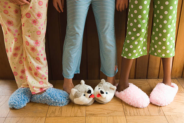 Pre-teen girls wearing fuzzy slippers - stock photo