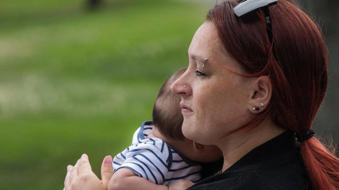 Mariska Kruger sits on a park bench in Napier with her youngest son. Photo / RNZ