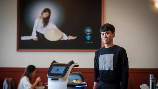 Dinh Quang Huy, manager, Try It Out Vietnamese Restaurant with the Pudu Bellabot waiter robot. (Photo / Michael Craig)