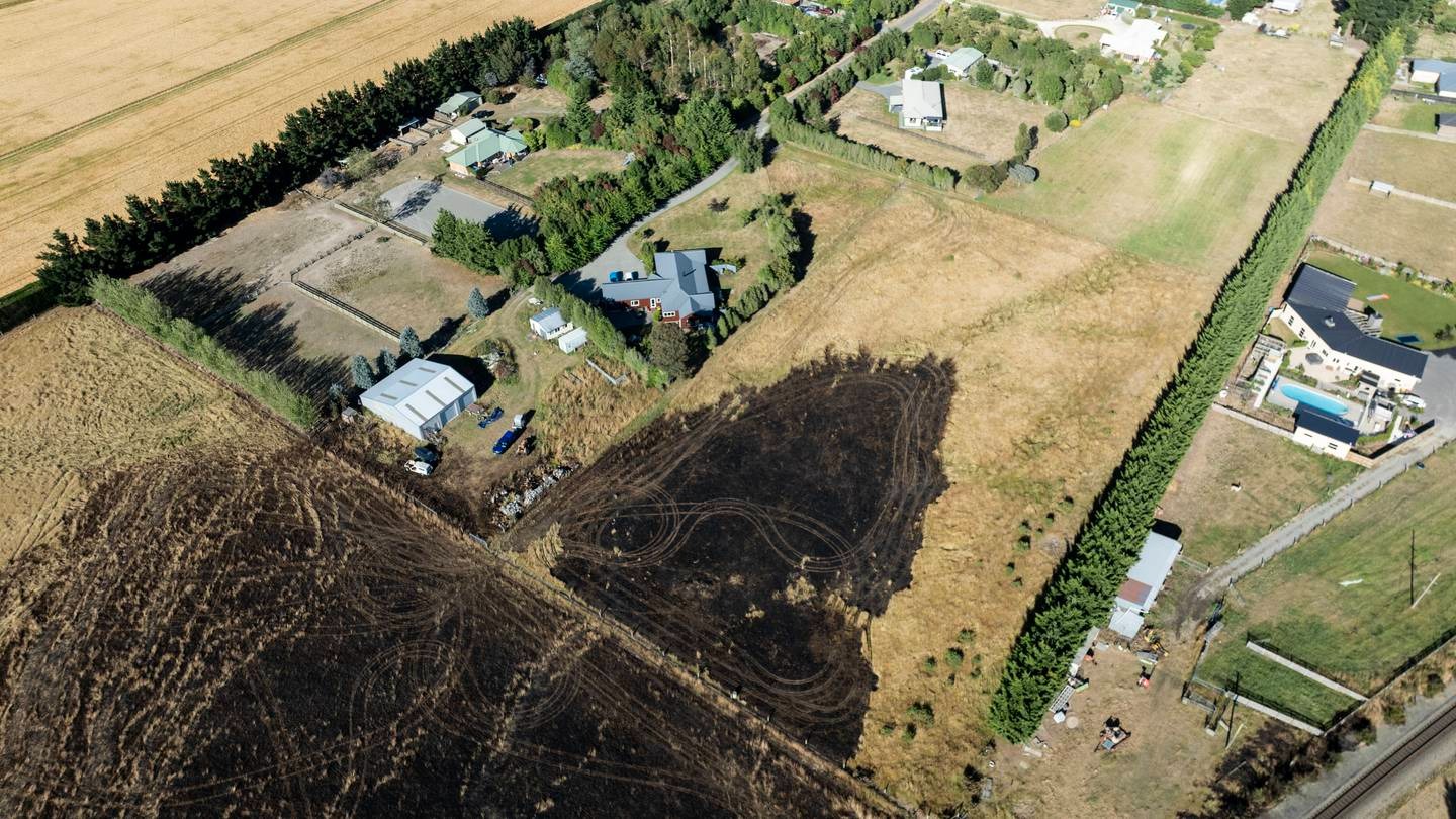 Dramatic images capture the scorched earth mere metres away from homes and buildings. Photo / George Heard