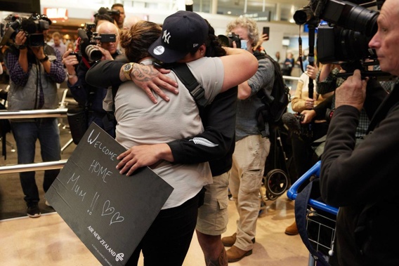 People embrace as they reunite at Auckland International Airport. (Photo / Bloomberg)