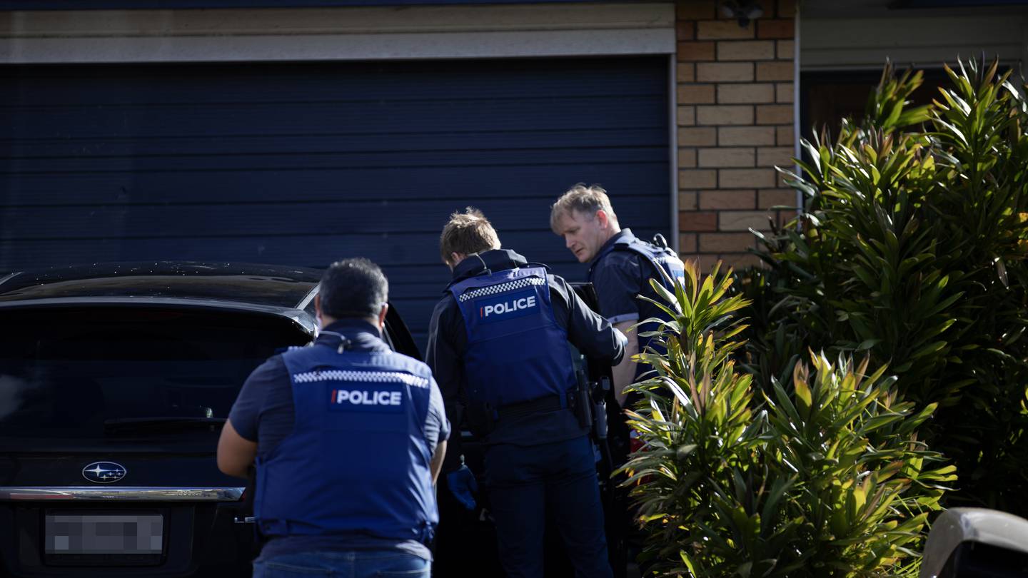 Police executing the warrant. Photo / Hayden Woodward