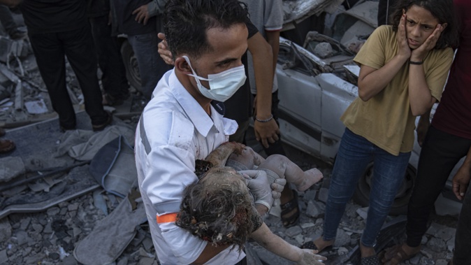 A Palestinian girl reacts as a baby is carried from the rubble of a building after an airstrike in Khan Younis, Gaza Strip, Saturday, Oct. 21, 2023. Photo / AP