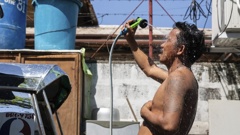 A man showers with a hose during hot weather in Manila, the Philippines on April 28, 2024. Earvin Perias/AFP/Getty Images
