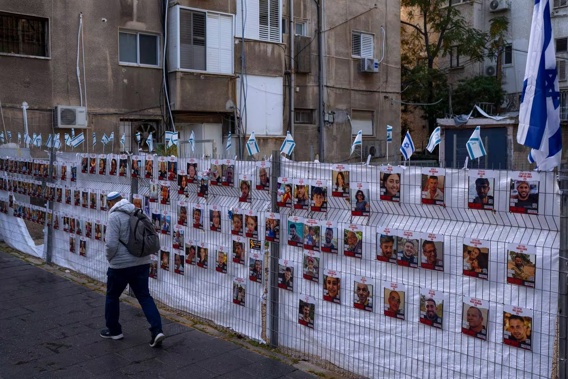 A man passes by a fence with photographs of hostages, mostly Israeli civilians who were abducted during the October 7, unprecedented Hamas attack on Israel. Photo / AP