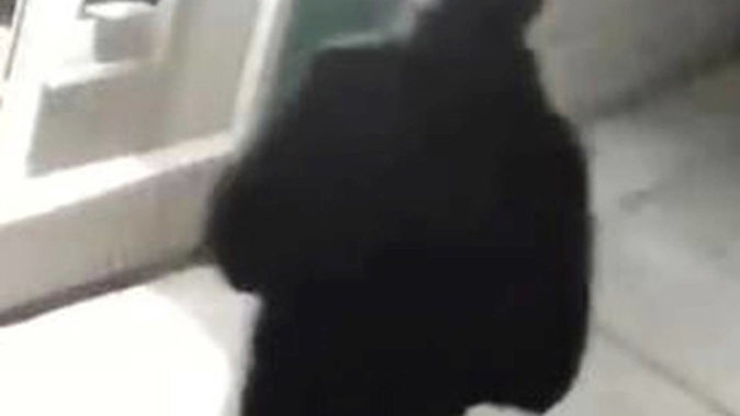 Authorities have released an image of a "person of interest," dressed all in black and wearing a black cap, who appeared in videos from several of the crime scenes. Photo / AP