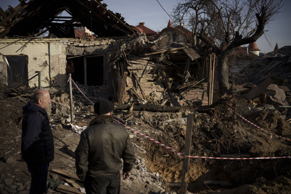 People stand next to the site of a Russian attack in Kyiv, Ukraine, Monday, Jan. 2, 2023. Photo / AP